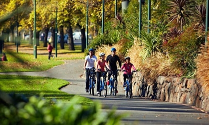 Family riding a bike through a park.